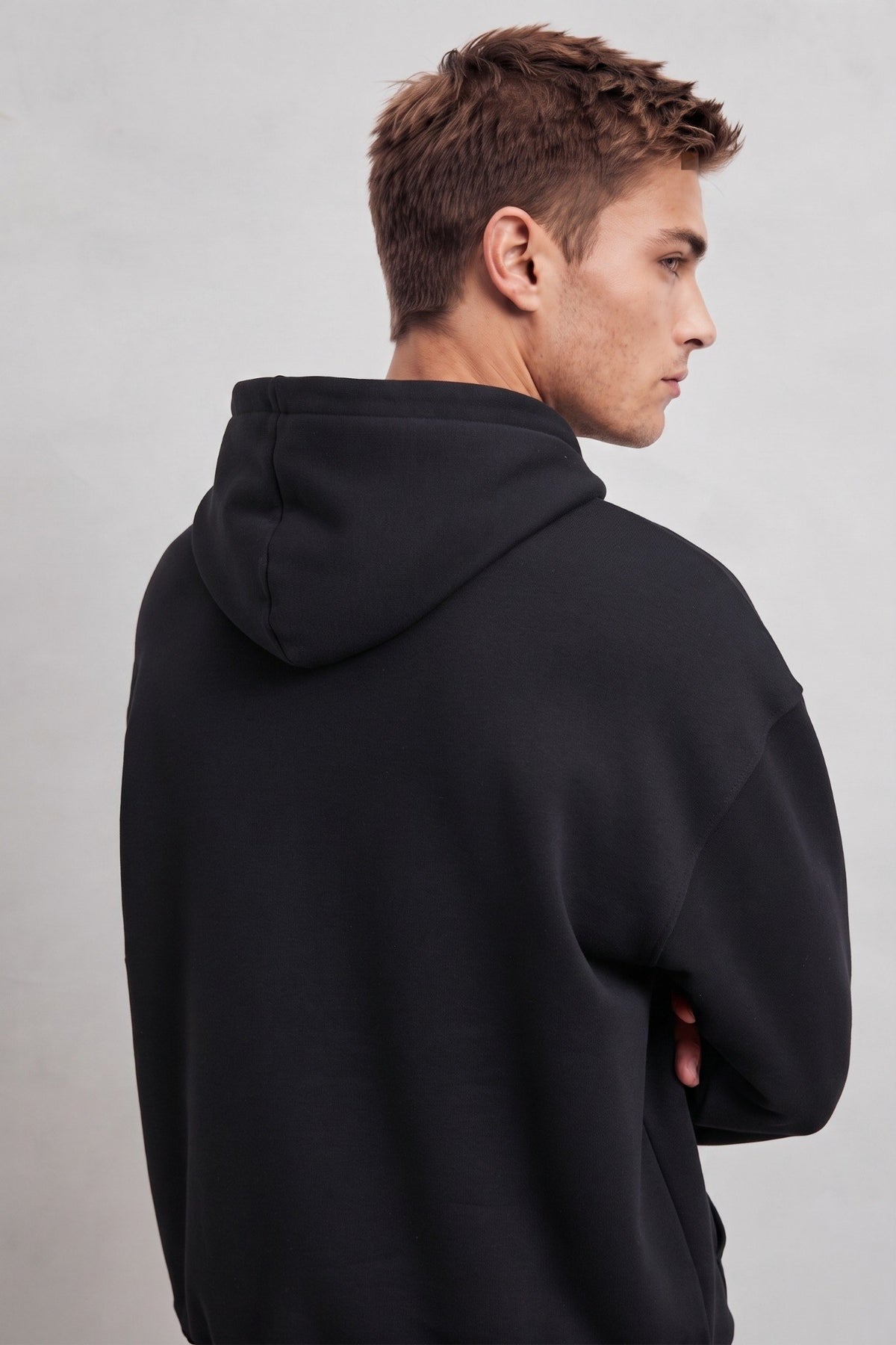 Detalle posterior de la capucha y corte oversize de la sudadera negra